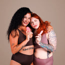 Je Joue Double Trouble Rechargeable Vibrator Set held by two women smiling in stylish swimwear.