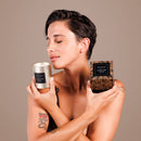 Je Joue Luxury Leather Massage Candle 160g being held by a woman in a serene, elegant setting.