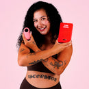 Ily By Je Joue Vibrating Cock Ring displayed by a smiling model, showcasing its design and packaging.