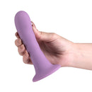 Love Notes Believe Silicone Dildo Dusty Plum held in hand, featuring a sleek design and soft plum color.