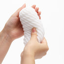 Person holding the Tenga 3DX Flow Male Masturbator, showcasing its unique molded design.