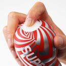 Close-up of a hand gripping the Super Tenga Meteor Smash Masturbator, showcasing its distinctive design and texture.