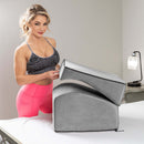 Liberator Flip Ramp Sex Positioning Pillow Lush Grey displayed by a model in fitness attire, showcasing its multi-use design.