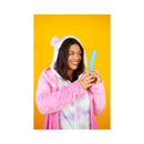A woman in a pink bear hoodie joyfully holding the Cute Little Fuckers Trinity Vibrator Teal against a bright yellow background.