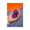 Cute Little Fuckers Princette Puppypus Purple held in hand on soft blanket.