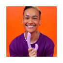 Cute Little Fuckers Jix Vibrator Lavender held by smiling person against vibrant orange background.
