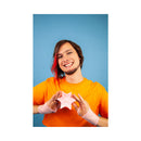 Person holding the Cute Little Fuckers Starsi Rose Silicone Palm Vibrator against a blue background.