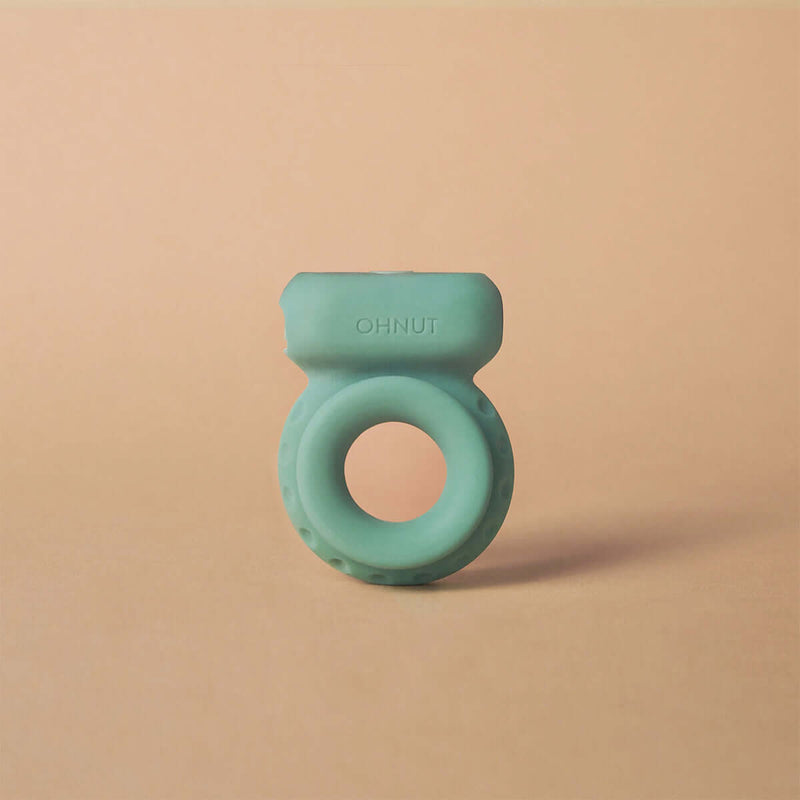 Ohnut Vibrating Penis Ring Jade on a textured surface, showcasing its soft and flexible design for enhanced intimacy.