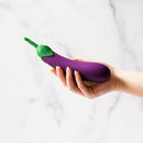 Emojibator Eggplant XL Emoji Vibrator Purple held in hand against a marble background.