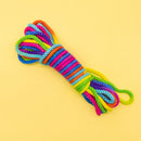 Emojibator Unicorn Rainbow Bondage Rope 26.25 Feet coiled in vibrant colors on a yellow background.