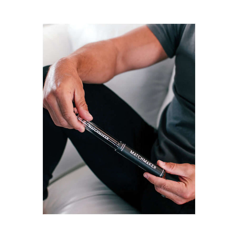 Eye of Love Matchmaker Black Diamond Attract Her Pheromone 10 ml held by a man in casual attire.