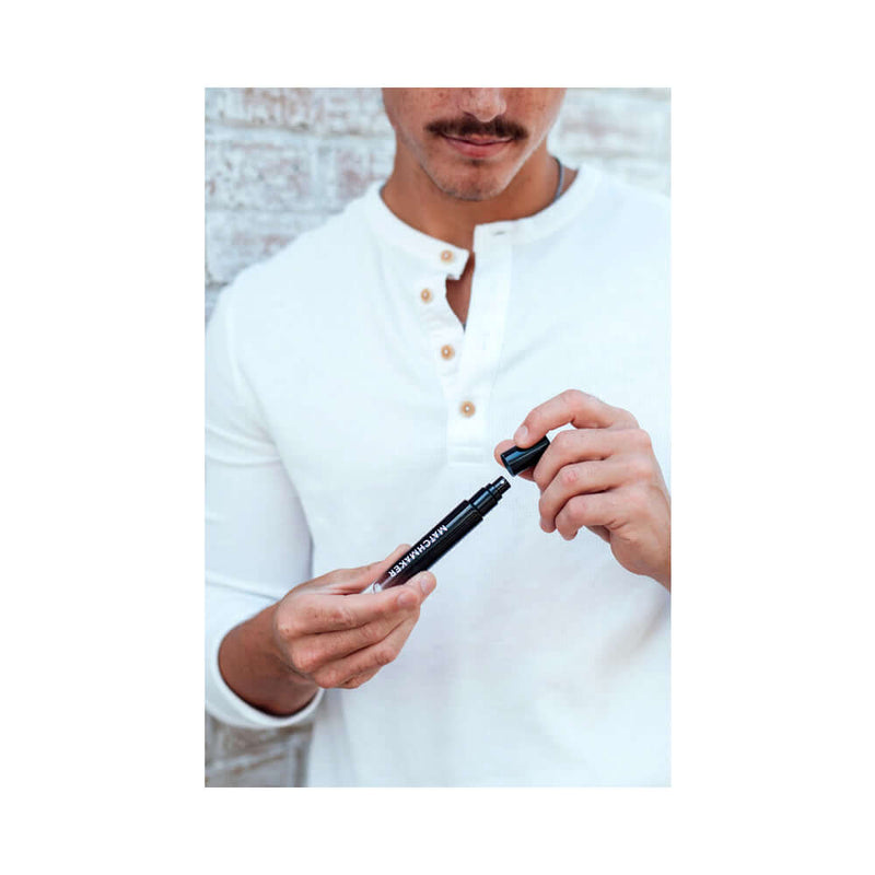 Man holding Eye of Love Matchmaker Black Diamond Attract Them Pheromone 10 ml, showcasing its sleek design.