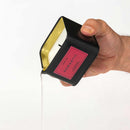 Hand holding an Eye of Love Romantic Attract Her Pheromone Massage Candle, pouring melted wax.