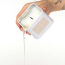 Eye of Love After Dark Attract Him Pheromone Massage Candle being poured from a stylish container.