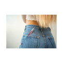 Eye Of Love One Love Attract Him Pheromone Parfum 10 Ml in a woman’s jeans pocket, showcasing a stylish fragrance.