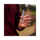 Person holding Eye of Love Unscented Male Pheromone Parfum 10 ml in a natural outdoor setting.