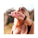 Eye Of Love Unscented Female Pheromone Parfum 10 mL held by a woman, showcasing its unique design in a natural setting.
