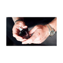 Person holding Eye of Love Matchmaker Black Diamond Attract Her Parfum 1 Oz in hands, showcasing the elegant bottle.