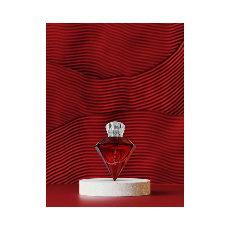 Eye of Love Matchmaker Red Diamond Attract Her Parfum 1 Oz displayed on a marble pedestal against a vibrant red background.