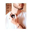 Close-up of a man holding Eye of Love Matchmaker Black Diamond Attract Him Parfum 1 Oz in his hand.