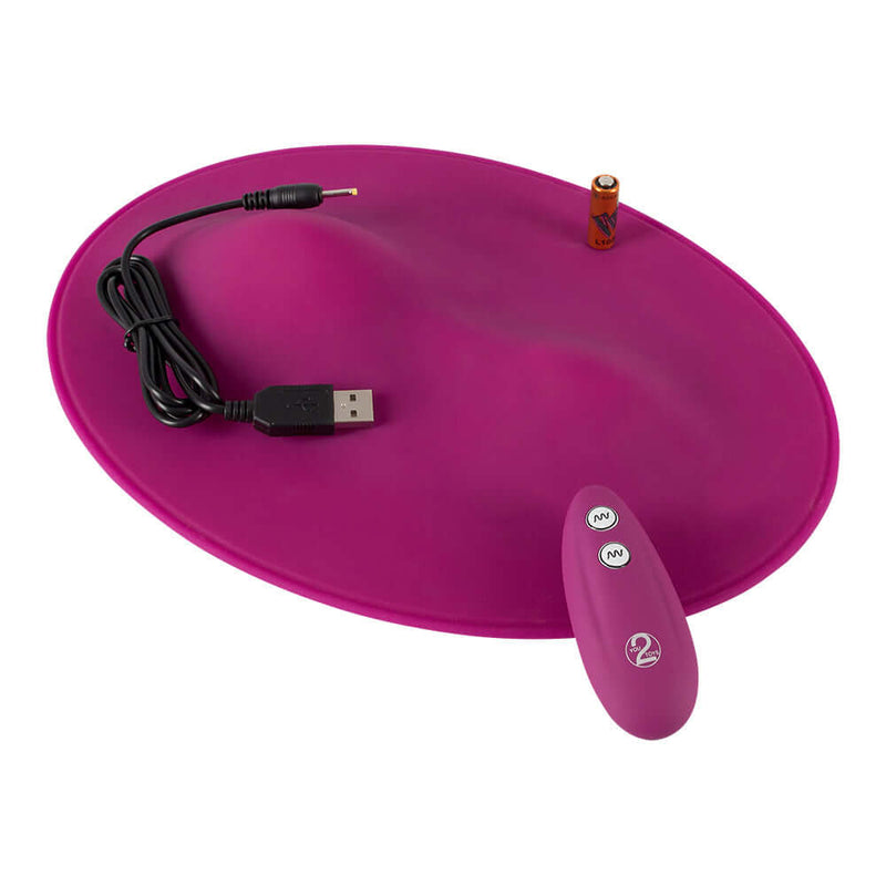 VibePad Hands Free External Vibrator featuring a pink silicone design, USB charging cord, and remote control for pleasure.