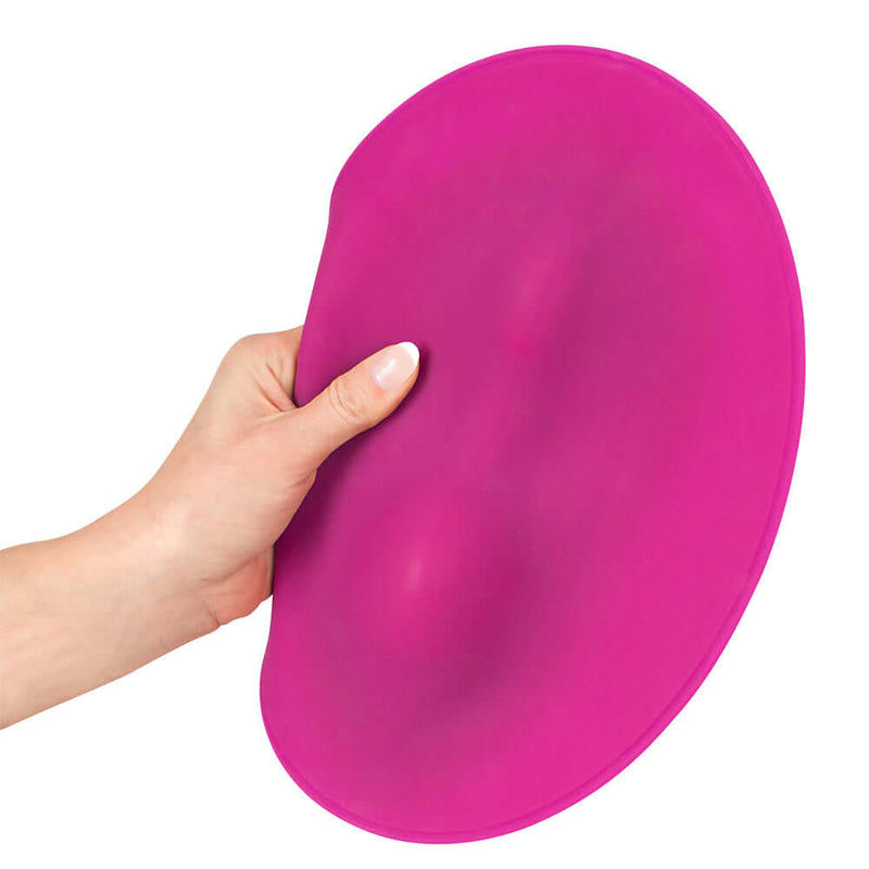 VibePad Hands Free External Vibrator being held with a focus on its unique shape and soft texture.