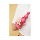 Strap-On-Me Dildo Plug Beads Large Raspberry held in hand against a yellow background, showcasing its ergonomic design.