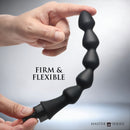 Master Series Canal 5 Bulb Silicone Enema Attachment Black held in hand, showcasing its firm and flexible design.