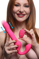 Strap U 30X Thrusting Vibrating Strapless Strap-On Pink held by a smiling woman, showcasing its remote control and thrusting feature.