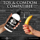 Master Series Jizz Unscented Water-Based Lube 16 Oz bottle held with a toy, showcasing compatibility.