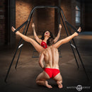 Master Series Throne Adjustable Sex Swing with Stand in a contemporary play space with a couple enjoying its features.
