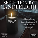 Bedroom Bliss Lover's Massage Candle Vanilla lit on bedside table, perfect for a romantic evening of massage.