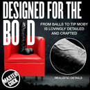Moby Huge 2 Foot Tall Super Dildo Black displayed on a red chair, showcasing realistic details and bold design.