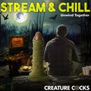 Creature Cocks Scaly Swamp Monster 3 Foot Giant Dildo beside a person relaxing in a spooky environment.