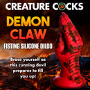 Creature Cocks Demon Claw Fisting Silicone Dildo Red in a fiery fantasy setting, showcasing its bold design and texture.
