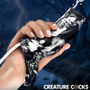 Hand holding Night Prowler Squirting Silicone Penis Enhancer Silver, showcasing dramatic texture and squirting feature.