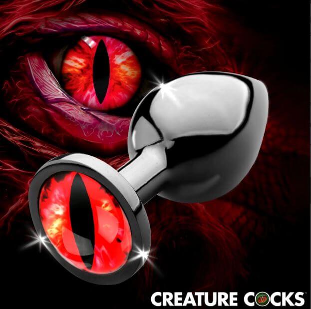 Creature Cocks Red Eye Metal Butt Plug Medium showcased against a vivid red eye background.