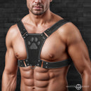 Master Series Alpha Pup Bulldog Harness Black worn by a muscular man showcasing its bold design and paw print emblem.