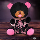 Master Series Bling Bondage Bear Plush Toy featuring pink cuffs and chains, heart pacifier, and soft black fur.