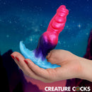 Creature Cocks Cosmo Hound Silicone Butt Plug held in hand against a starry background.