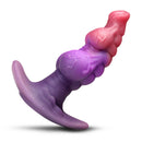 Creature Cocks Dragon Master Silicone Butt Plug showcasing a colorful, curvy design for P-spot stimulation.