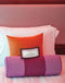 Decorative pillows on a bed with a playful romantic coupon for intimate scenarios, enhancing bedroom fun and excitement.