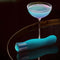 Oh My Gem Fierce Blue Topaz rechargeable vibrator beside a cocktail, highlighting sensuality and self-exploration.