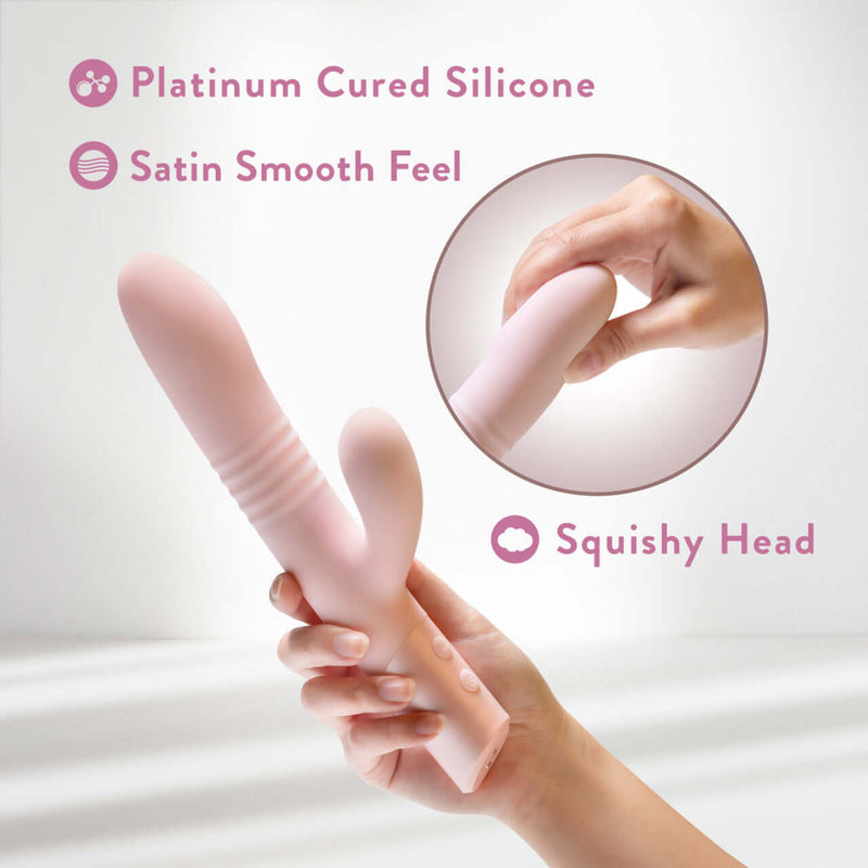 Holding Blush Fraya Pink Rabbit Style Vibrator made with platinum cured silicone, showing its satin smooth feel and squishy head.