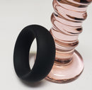 Spartacus Wide Silicone Donut Cock Ring 1.5 Inch Black next to a pink glass toy, emphasizing its sleek design and functionality.