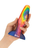 Hand holding the b-Vibe Peace and Love Tie-Dye Rimming Plug Special Edition with vibrant tie-dye design.