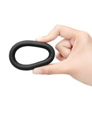 b-Vibe Snug Ring 45 mm Stretch Silicone Cock Ring Black held in a hand, showcasing its flexible design and body-safe material.