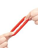 b-Vibe Flex Ring Grip Super Soft Silicone Cock Ring Red held in hands, showcasing its soft, flexible design.