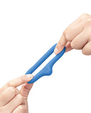 b-Vibe Flex Ring Drip Super Soft Silicone Cock Ring Blue being held with two hands to show its flexible design.