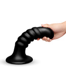 b-Vibe Krush 9.5 Inch Curved Ribbed XXL Suction Cup Dildo held in hand showing its textured design.